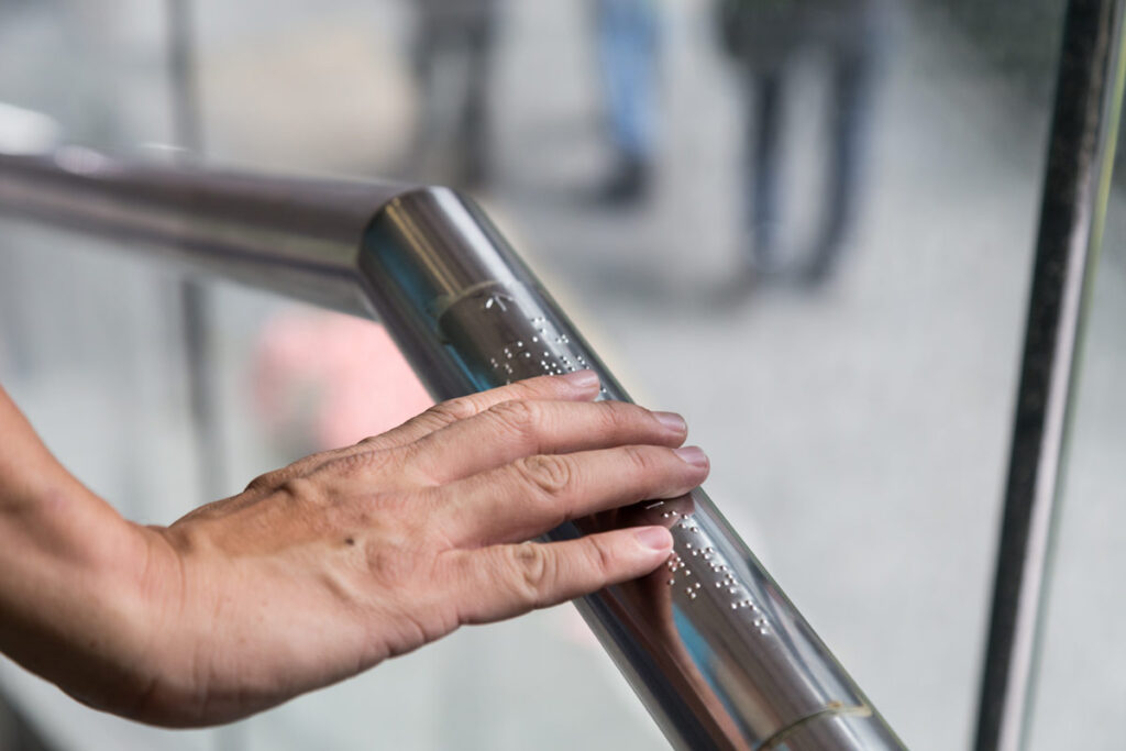 handlaufschild-aus-silbernem-aluminium-mit-blindenschrift-und-pfeil-barrierefreie-beschilderung